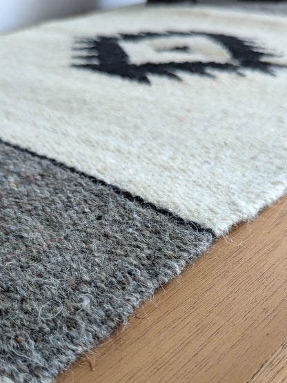 Petit kilim crème et gris en laine, détail du tissage et du motif noir