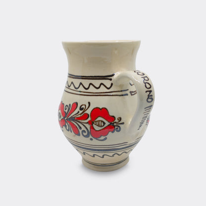 Pichet en céramique de Corund avec décor floral rouge peint à la main. Une faïence artisanale de Transylvanie.