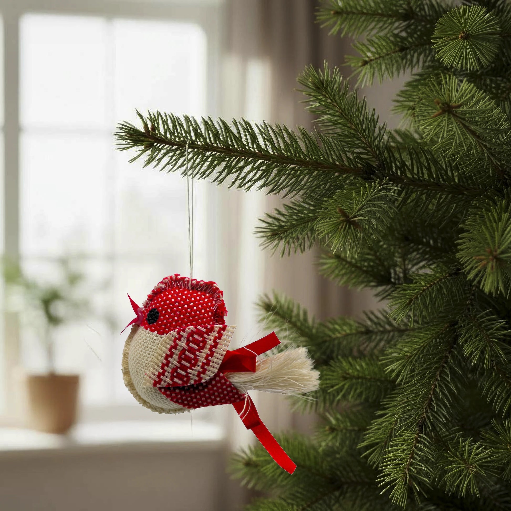 Oiseau rouge et écru à bec rouge dans un sapin accroché à une branche, entièrement fait main