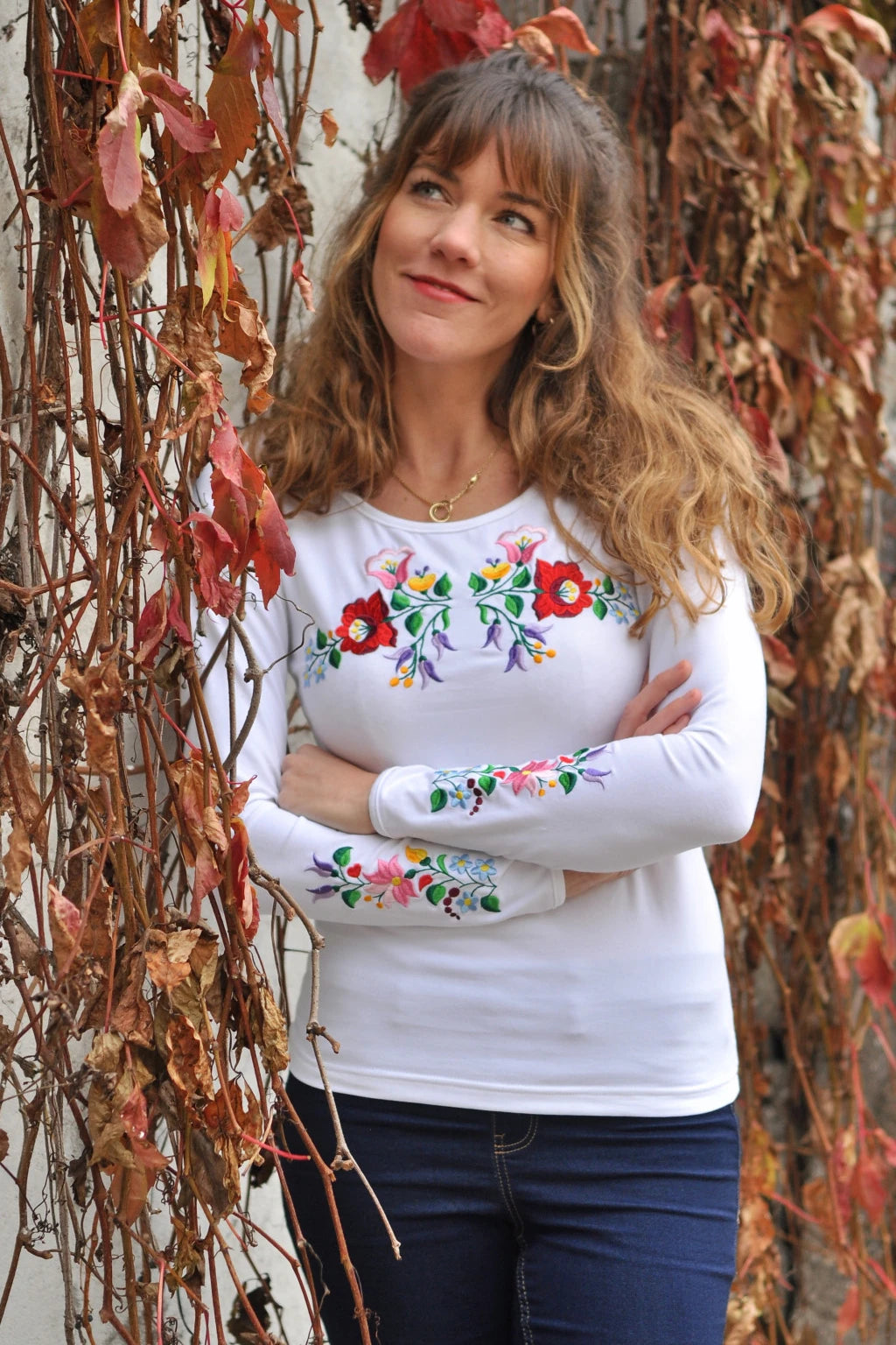 T shirt blanc à manches longues avec des broderies à fleurs Kalocsa sur la poitrine et les manches. Vue en entier
