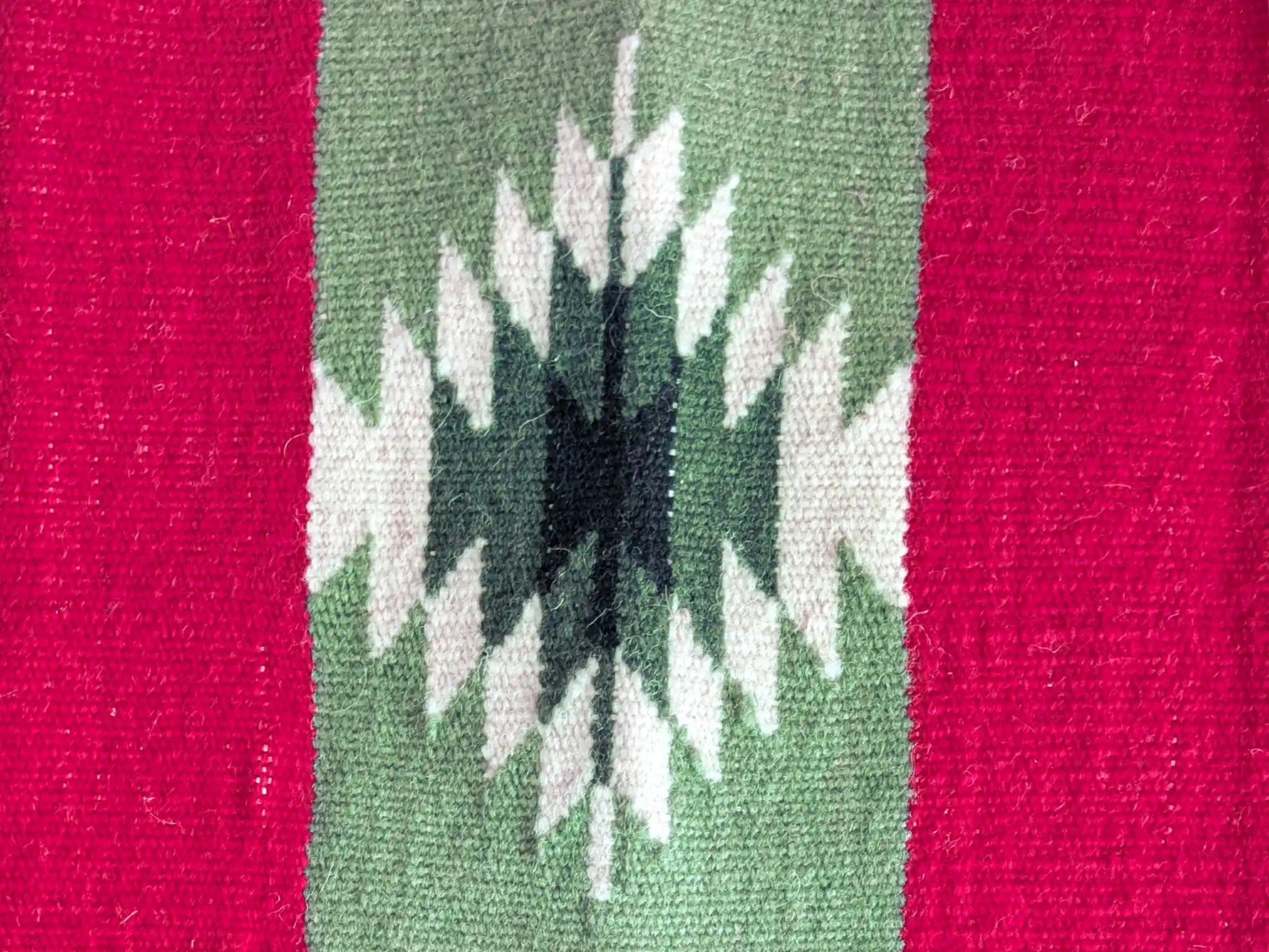 Tapis kilim avec détail d’une bande géométrique noire et blanche sur fond vert olive