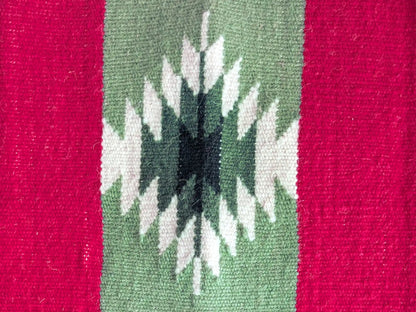 Tapis kilim avec détail d’une bande géométrique noire et blanche sur fond vert olive