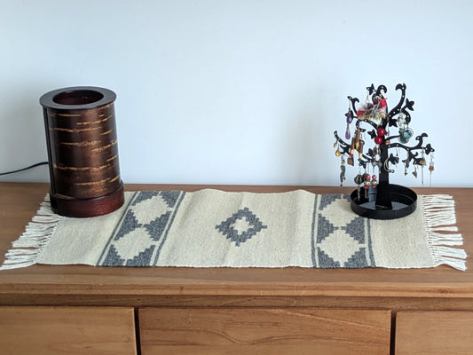 Tapis kilim gris et crème en laine, tissé main au Monténégro, présenté en situation avec motifs géométriques