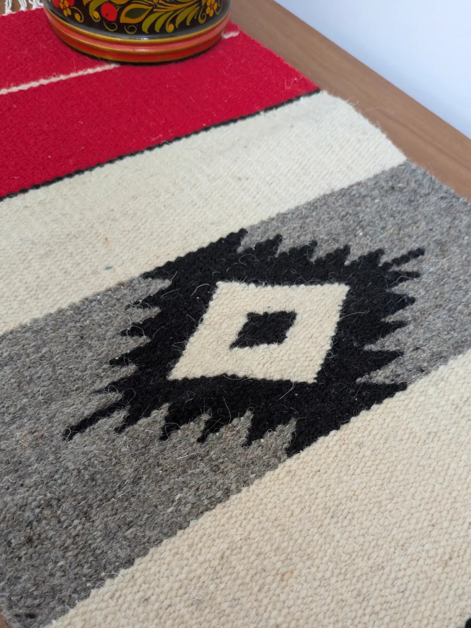Tapis kilim avec détail du motif losange central noir, sur fond écru et gris