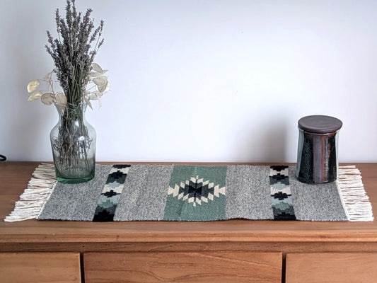 Tapis kilim vert olive et gris en laine, tissé main au Monténégro, présenté en situation avec motifs géométriques