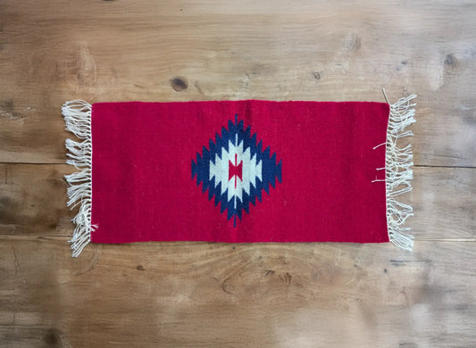 Tapis des Balkans rouge 30×60 en laine, avec un motif losange tissé. Une pièce artisanale simple et géométrique, fidèle au style traditionnel.