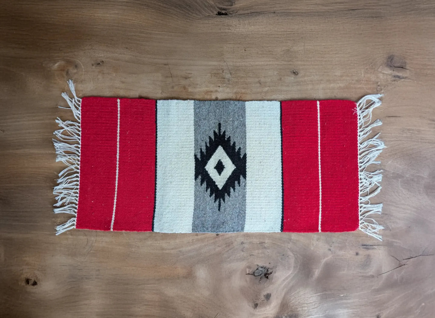 Petit tapis balkanique en laine rouge et gris, tissé à la main. Motif central en losange noir et blanc cassé. Composition simple et traditionnelle.