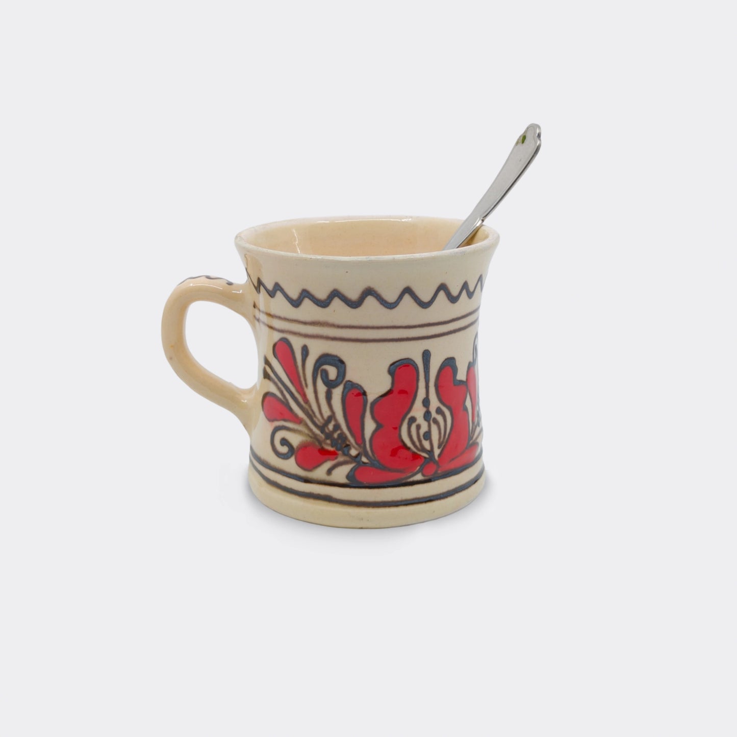 Mug traditionnel Corund fait main, décor floral rouge et fond crème émaillé. Céramique artisanale transylvaine.