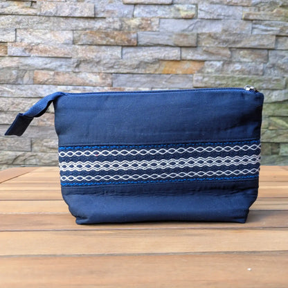 Trousse de toilette artisanale bleue avec bande tissée décorative sur le devant.