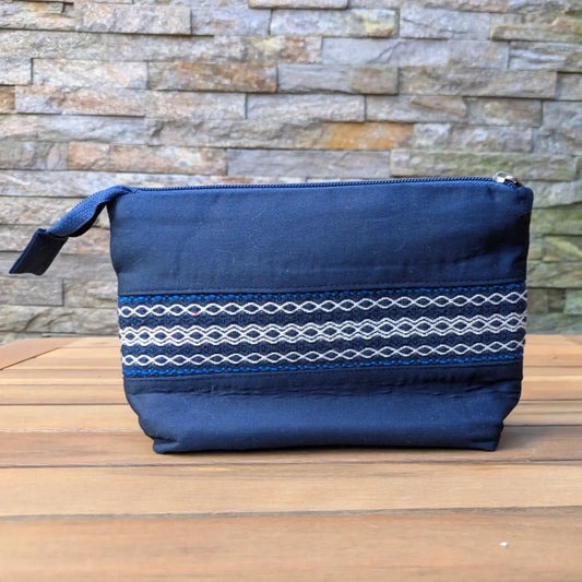 Trousse de toilette artisanale bleue avec bande tissée décorative sur le devant.