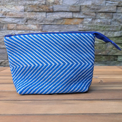 Trousse de toilette artisanale bleu et blanc, tissée main en chevrons avec fermeture zippée bleue.