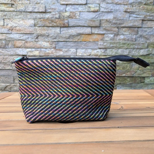 Trousse de toilette artisanale multicolore tissée main en chevrons, avec fermeture zippée noire.