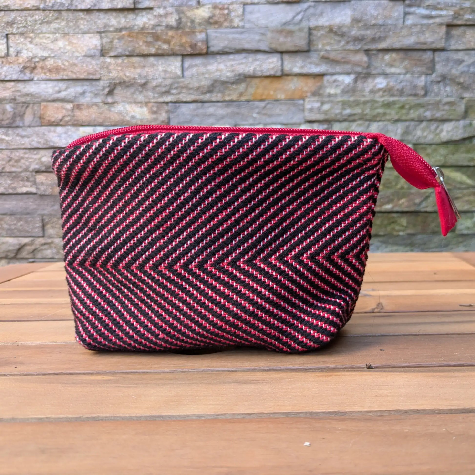 Trousse de toilette artisanale rouge et noir, tissée main en chevrons avec fermeture zippée assortie.
