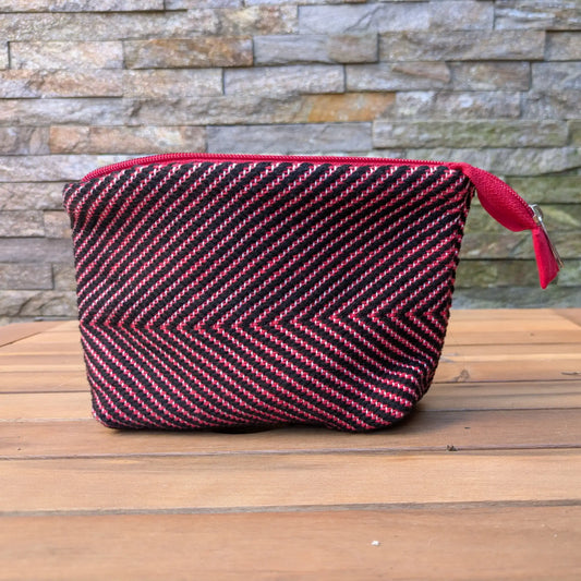 Trousse de toilette artisanale rouge et noir, tissée main en chevrons avec fermeture zippée assortie.