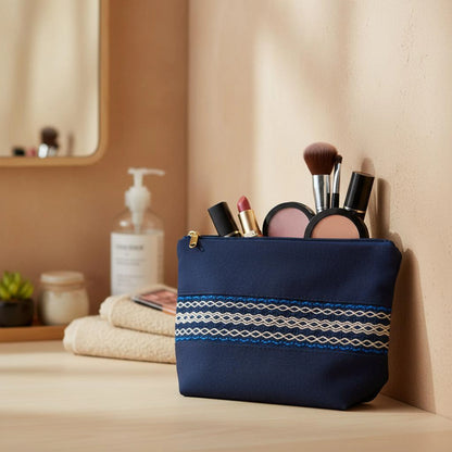 Trousse artisanale bleue posée dans une salle de bain, contre le mur, contenant du maquillage