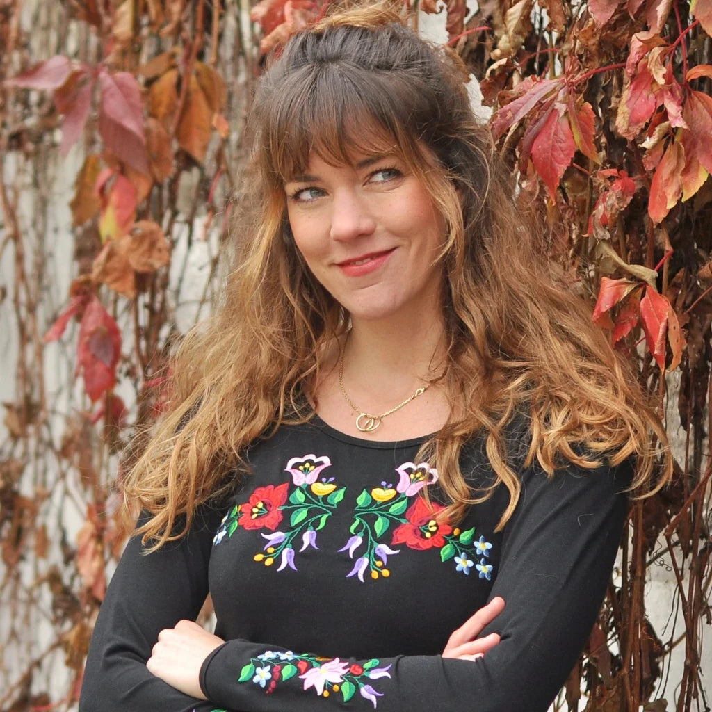 T-shirt noir à manches longues brodé avec des fleurs selon le type de broderie hongroise Kalocsa du patrimoine hongrois. Vue de face rapprochée.