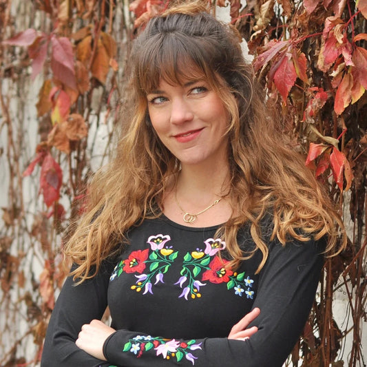 T-shirt noir à manches longues brodé avec des fleurs selon le type de broderie hongroise Kalocsa du patrimoine hongrois. Vue de face rapprochée.