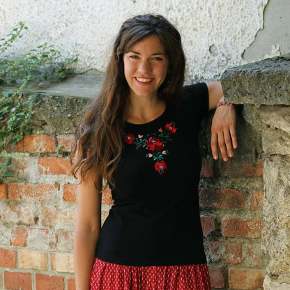 Les broderies hongroises si caractéristiques ornent ce Tshirt noir à manches courtes. Les rouges dominants des fleurs et le vert des délicates feuilles ressortent particulièrement bien sur le noir de ce haut pour femmes