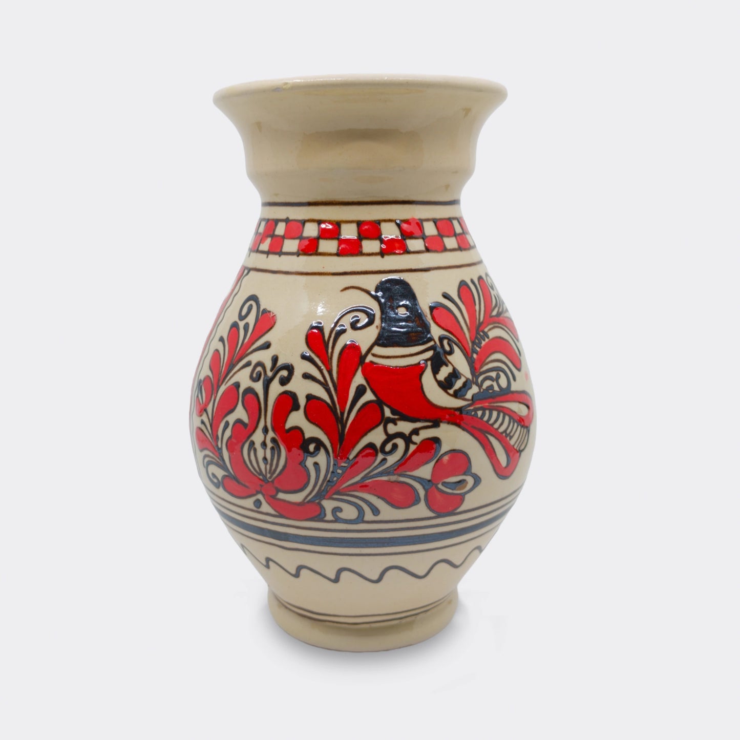 Vase en céramique de Corund en faïence artisanale. Décor floral rouge peint à la main sur fond crème. Motifs székely soulignés de brun-noir.