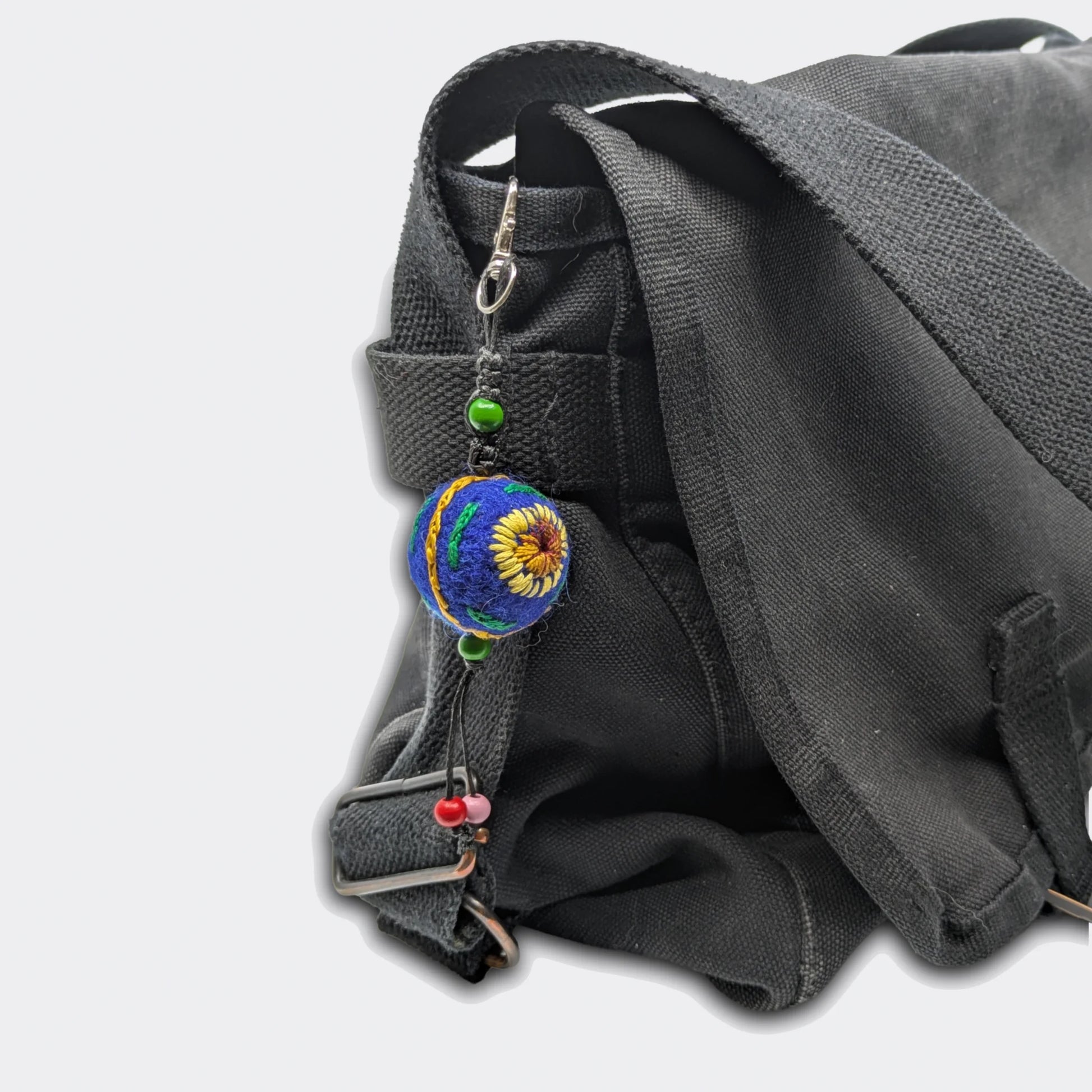 Suspension décorative Zlata avec petite boule en feutre bleue nuit et tournesols brodés. Sur sac.
