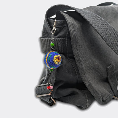 Suspension décorative Zlata avec petite boule en feutre bleue nuit et tournesols brodés. Sur sac.