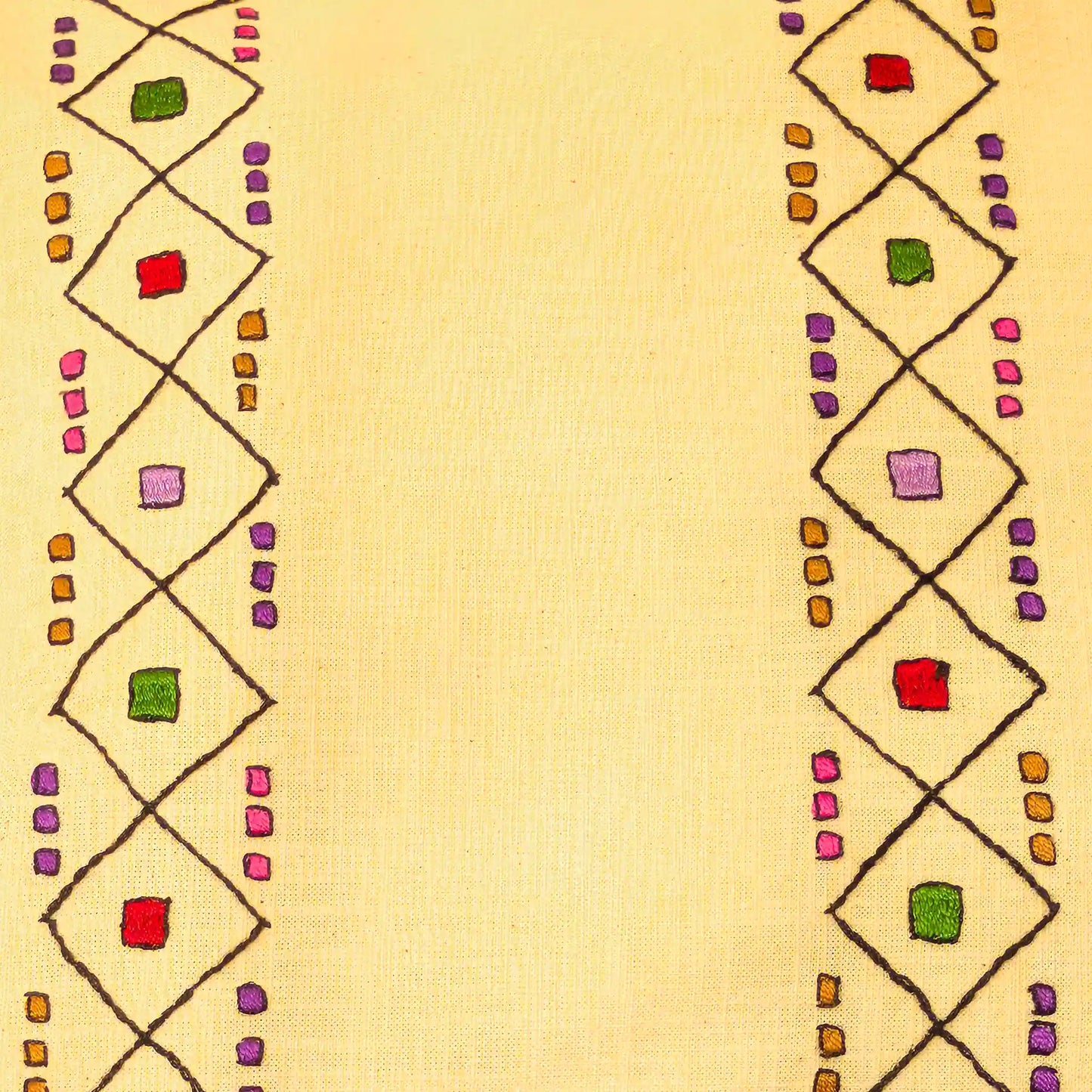 Gros plan sur les motifs géométriques de Šumadija brodés sur housse de coussin à la main.